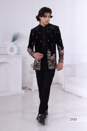 Man wearing a black velvet embroidered bandhgala with silver and maroon elephant and floral motifs.