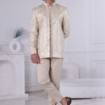 Man wearing an ivory malai silk Jodhpuri suit with sequin embroidery and geometric design.