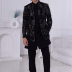 Man wearing a black Jodhpuri suit with sequin embroidery in geometric and floral design.