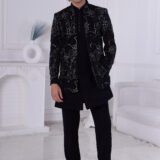 Man wearing a black Jodhpuri suit with sequin embroidery in geometric and floral design.
