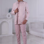 Man wearing a blush pink embroidered Jodhpuri suit with delicate detailing.