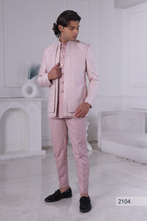 Man wearing a blush pink embroidered Jodhpuri suit with delicate detailing.