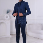 Man wearing a navy blue embroidered Jodhpuri suit with thread and sequin detailing.