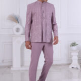Man wearing a lavender embroidered Jodhpuri suit with vertical patterns and detailed hem design, posing indoors.