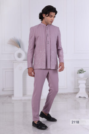 Man wearing a lavender embroidered Jodhpuri suit with vertical patterns and detailed hem design, posing indoors.