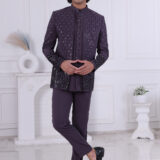 Man wearing a deep purple Jodhpuri suit with vertical sequin patterns and floral embroidery on sleeves and hem.
