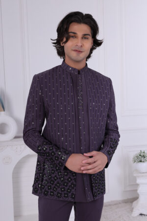 Man wearing a deep purple Jodhpuri suit with vertical sequin patterns and floral embroidery on sleeves and hem.