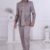 Man wearing a grey embroidered Jodhpuri suit with metallic detailing and ornate buttons.