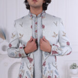 Man wearing a pastel blue floral embroidered Jodhpuri suit with contrast piping.