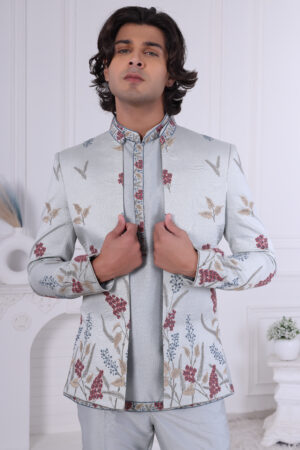 Man wearing a pastel blue floral embroidered Jodhpuri suit with contrast piping.