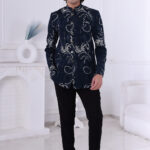 Man dressed in a navy blue Jodhpuri suit featuring silver embroidered motifs and a checkered pattern.