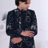 Man dressed in a navy blue Jodhpuri suit featuring silver embroidered motifs and a checkered pattern.