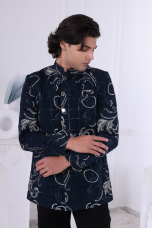 Man dressed in a navy blue Jodhpuri suit featuring silver embroidered motifs and a checkered pattern.
