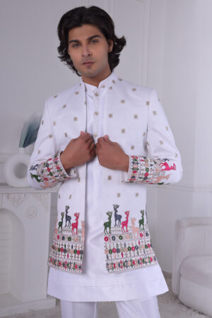 Man wearing a white Jodhpuri suit featuring golden embroidery and colorful deer motifs on the cuffs and hemline.
