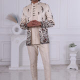 Man wearing an ivory Jodhpuri suit with maroon and black floral embroidery.