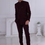 Man wearing a maroon Jodhpuri suit with subtle embroidery and statement buttons.