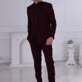 Man wearing a maroon Jodhpuri suit with subtle embroidery and statement buttons.