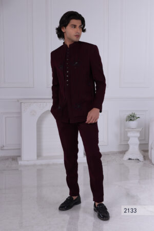 Man wearing a maroon Jodhpuri suit with subtle embroidery and statement buttons.