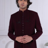 Man wearing a maroon Jodhpuri suit with subtle embroidery and statement buttons.