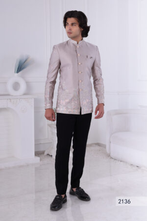 Man wearing an ivory silk embroidered Jodhpuri suit with pastel floral and elephant motifs.