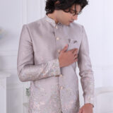 an wearing an ivory silk embroidered Jodhpuri suit with pastel floral and elephant motifs.