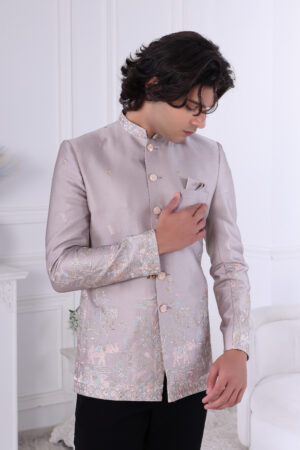 an wearing an ivory silk embroidered Jodhpuri suit with pastel floral and elephant motifs.