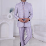 Man wearing a lavender silk brocade Jodhpuri suit with gold button detailing.