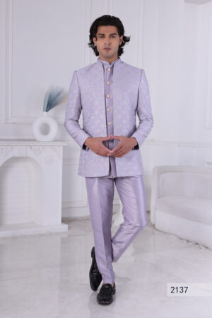 Man wearing a lavender silk brocade Jodhpuri suit with gold button detailing.