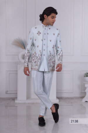 Man wearing an ice-blue Jodhpuri suit with detailed floral embroidery and silver buttons.