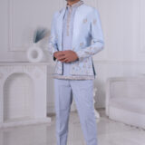 Man wearing a powder blue Jodhpuri suit with pastel floral embroidery and coordinated kurta-pajama.