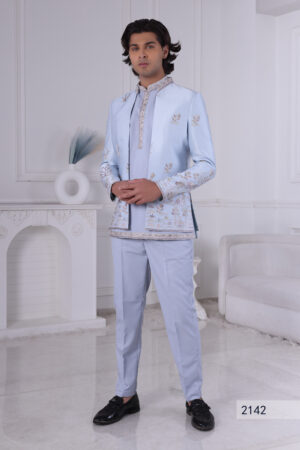 Man wearing a powder blue Jodhpuri suit with pastel floral embroidery and coordinated kurta-pajama.