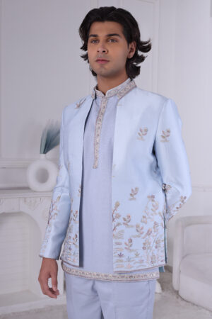Man wearing a powder blue Jodhpuri suit with pastel floral embroidery and coordinated kurta-pajama.