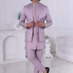 A man wearing a lavender Jodhpuri suit with metallic embroidery on the sleeves and hem, paired with a matching kurta and trousers.