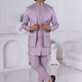 A man wearing a lavender Jodhpuri suit with metallic embroidery on the sleeves and hem, paired with a matching kurta and trousers.