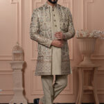 Men’s beige Indo-Western outfit with floral embroidery and mirror work jacket.