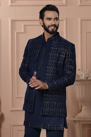 Men’s navy blue velvet Indo-Western with embroidered jacket, paired with matching kurta and trousers.