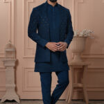 Men’s navy blue Indo-Western outfit with embroidered jacket, styled with matching kurta and trousers.