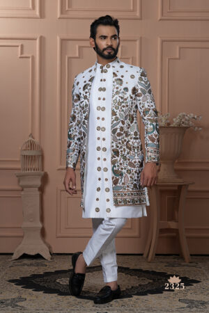 Men’s white Indo-Western outfit with embroidered jacket in floral and peacock designs, paired with plain kurta and churidar.