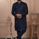 Men’s navy blue Indo-Western outfit with textured geometric jacket and metallic button kurta.