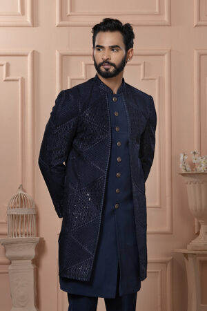 Men’s navy blue Indo-Western outfit with textured geometric jacket and metallic button kurta.