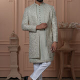 Men’s pastel green Indo-Western outfit with embroidered floral jacket and front-buttoned kurta.