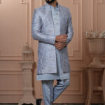 Men’s powder blue Indo-Western outfit with embroidered jacket and metallic-buttoned kurta.