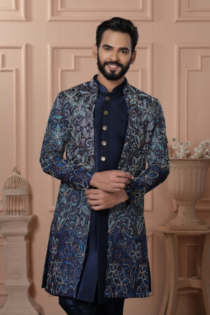 Men’s navy blue Indo-Western outfit with floral embroidered jacket and metallic button kurta.