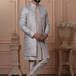 Men’s champagne beige Indo-Western outfit with silver embroidered jacket and matching kurta set.