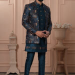 Men’s teal blue Indo-Western outfit with embroidered jacket and matching kurta set.