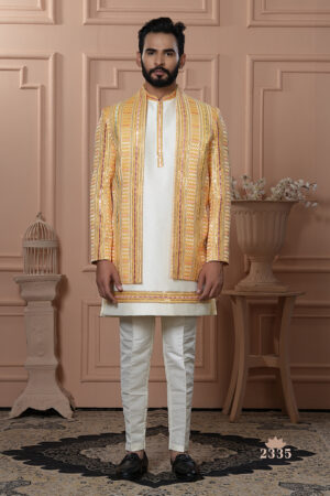 Men’s yellow Indo-Western outfit with ivory kurta and mirror work embroidered jacket.