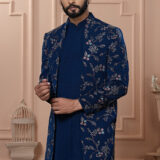 Man wearing navy blue Indo-Western outfit with floral embroidered long jacket.