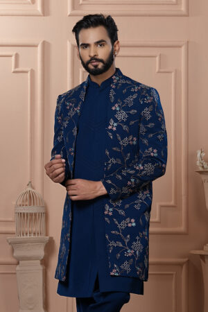 Man wearing navy blue Indo-Western outfit with floral embroidered long jacket.