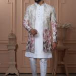 Man wearing white Indo-Western with a multicolor floral embroidered jacket.
