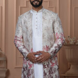 Man wearing white Indo-Western with multicolor floral embroidered jacket.